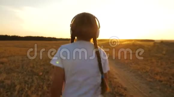 青少年女孩在日落时训练听音乐运动女孩戴着耳机慢跑视频的预览图
