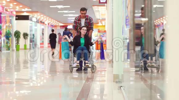 一个男人在购物中心买了一个坐轮椅的残疾妇女后很幸运他们在玩他们在笑视频的预览图