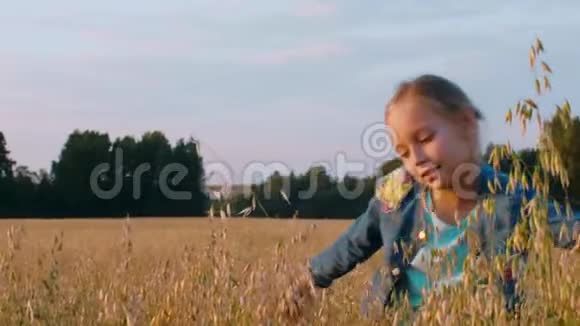 可爱的少年女孩在田野上触摸小麦和滑稽的舞蹈视频的预览图