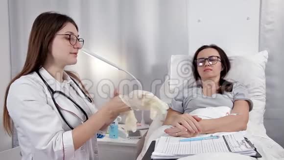 年轻的女医生戴上手套检查病人视频的预览图