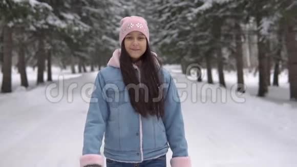 一个女孩走过一个冬天的森林身体很好旋转视频的预览图