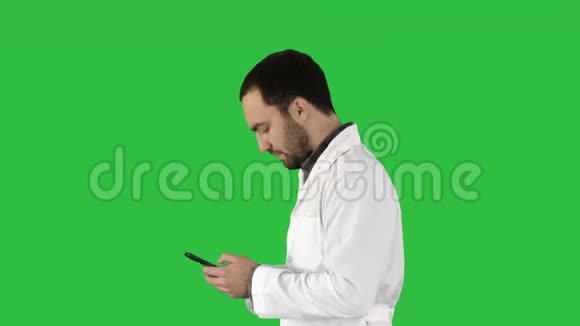 步行医生或护士在绿色屏幕上的手机上发短信Chroma键视频的预览图