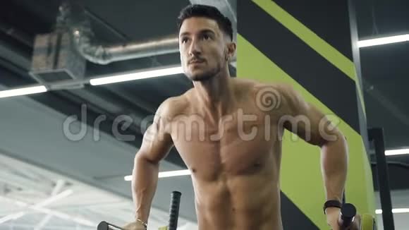 强壮的年轻人在健身房的双杠上做拉力运动视频的预览图