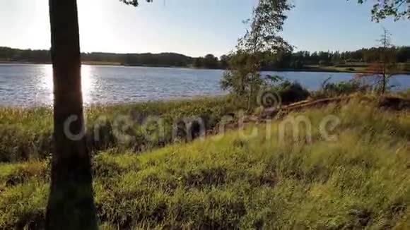 夏日在湖上欣赏日落美景湖和天空汇聚在地平线上视频的预览图