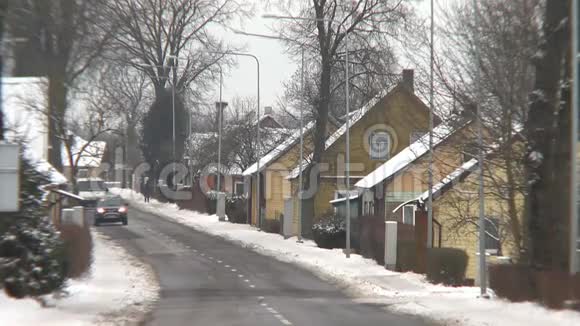 农村的房屋和汽车在冬天穿过街道视频的预览图