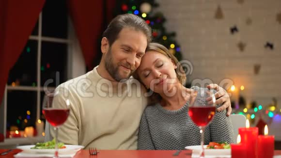 温柔的情侣拥抱圣诞装饰闪闪发光幸福的家庭肖像视频的预览图