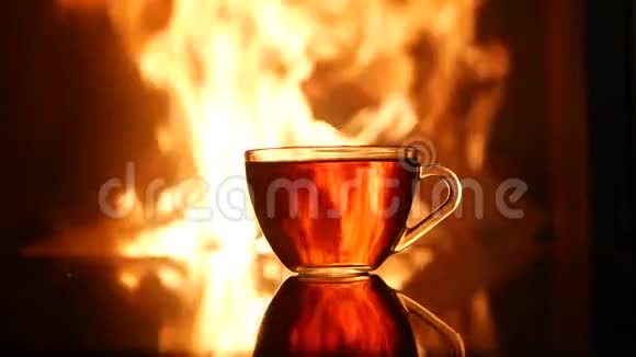 壁炉火焰背景下的一杯茶视频的预览图