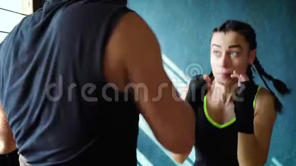 与拳击教练在健身房进行的适合白人女性拳击手训练的特写镜头视频的预览图