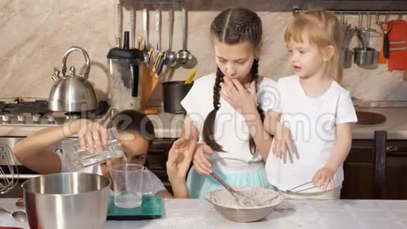 妈妈正在厨房里和她的两个女儿做饭视频的预览图