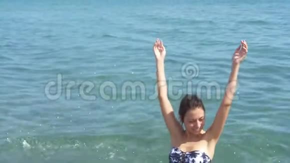 一个女孩在海里洗澡溅水慢镜头射击穿泳衣的女孩视频的预览图