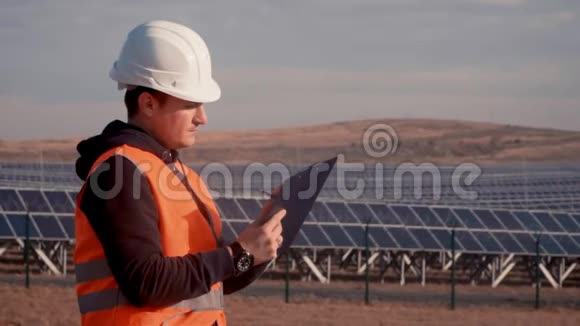 年轻工程师在太阳能发电厂检查太阳能电池板视频的预览图