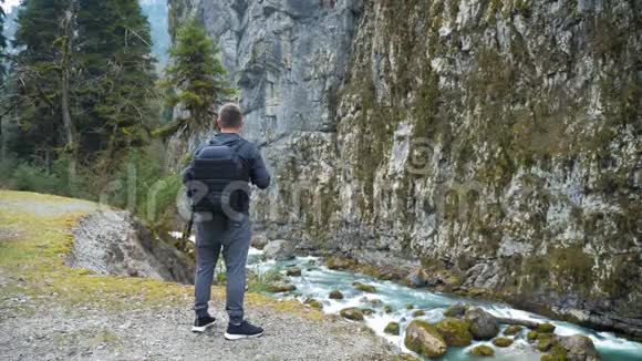 男子旅游徒步旅行者带背包欣赏风景秀丽的山河景观旅行徒步旅行者远离旅行人们视频的预览图