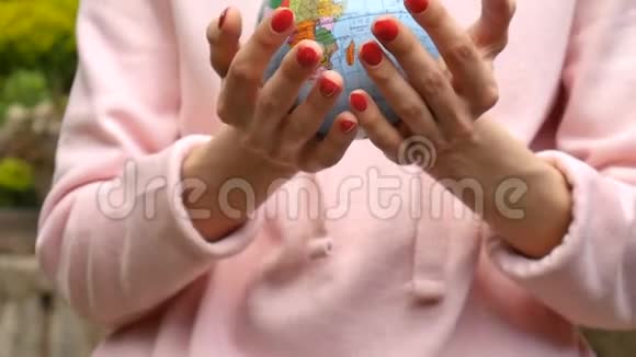 有红色指甲的女性手上面有一个小地球仪上面有用乌克兰西里尔字母命名的地理图形人类视频的预览图