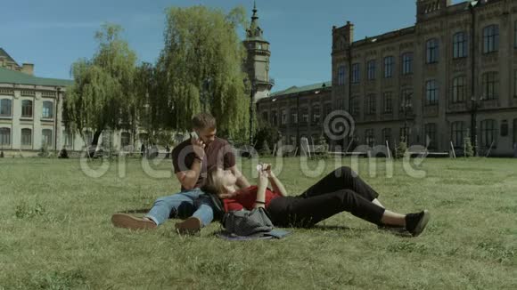 校园草坪上使用手机的大学生视频的预览图