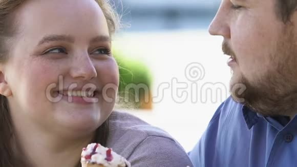一对快乐浪漫的肥胖夫妇在约会时玩得开心吃冰激凌视频的预览图