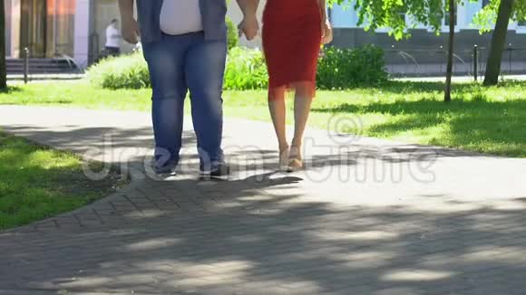 体重超标的男子与苗条迷人的女人穿着红色的衣服散步身体积极视频的预览图