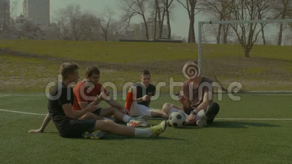 拥有智能手机的足球队在足球场休息视频的预览图