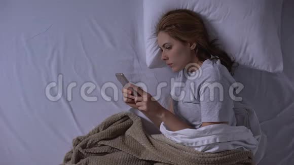 迷人的女人躺在床上睡觉前和男朋友聊天视频的预览图