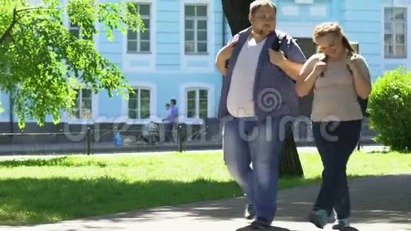 快乐的超重男女在公园散步浪漫的约会身体积极视频的预览图