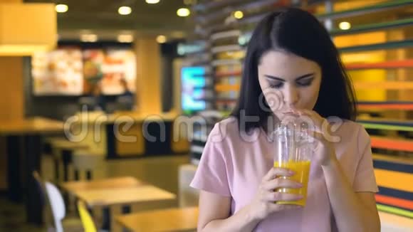 美丽的女性喝橙汁微笑新鲜的酒吧鸡尾酒维生素视频的预览图