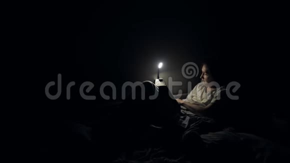小女孩晚上在床上用灯看书视频的预览图