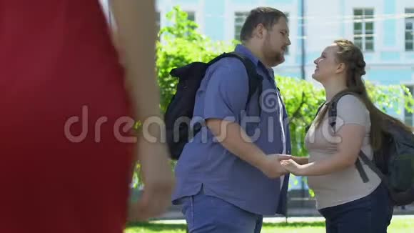 丰满的男人看着红衣女郎肥胖的女朋友嫉妒关系视频的预览图
