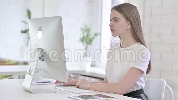 年轻女性思考与办公室桌面工作视频的预览图