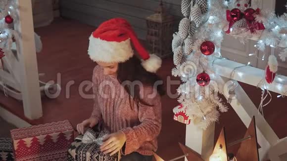 戴着圣诞帽包装礼物的漂亮女孩视频的预览图