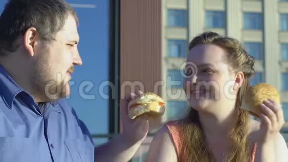 快乐又大的情侣约会时互相吃高脂肪的汉堡视频的预览图