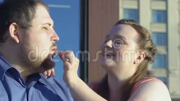 漂亮丰满的女人对待男朋友炸薯条快餐胖夫妇约会视频的预览图