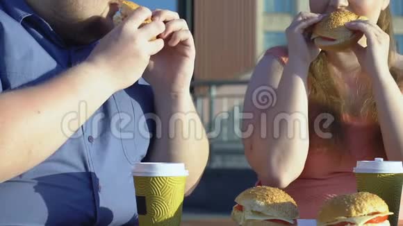 另外一对夫妇在街头咖啡馆吃高热量汉堡肥胖问题视频的预览图