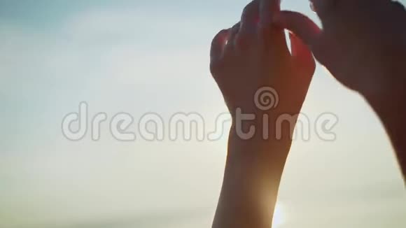 水中日出时美丽的年轻女子她过着健康的生活方式双手在黎明的背景上视频的预览图