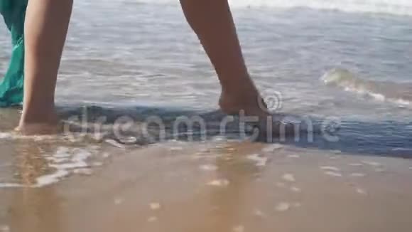 雌性赤着脚在海滩上潮湿的沙子上行走慢动作视频的预览图