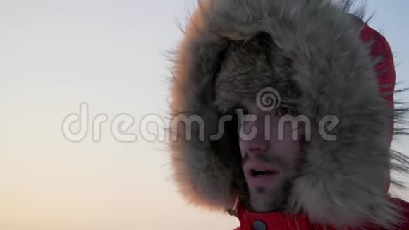 一个寒冷的人呼吸在他的手上热身一个衣着热情的人在寒冷中冻僵了关门视频的预览图
