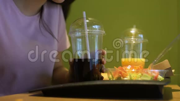 年轻女子用吸管品尝软饮料学生在咖啡馆吃午餐视频的预览图