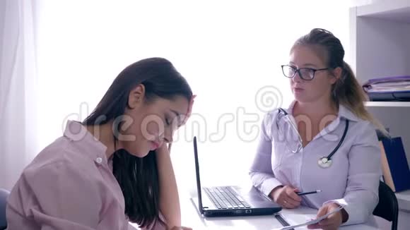 悲伤的病人坐在他们的顾问医生面前在生育诊所的桌子上视频的预览图