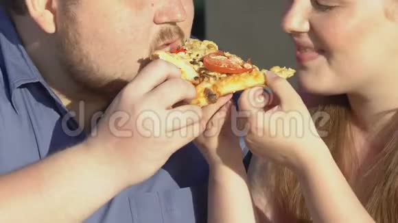 快乐加码夫妇一起吃美味的披萨片超重快餐视频的预览图