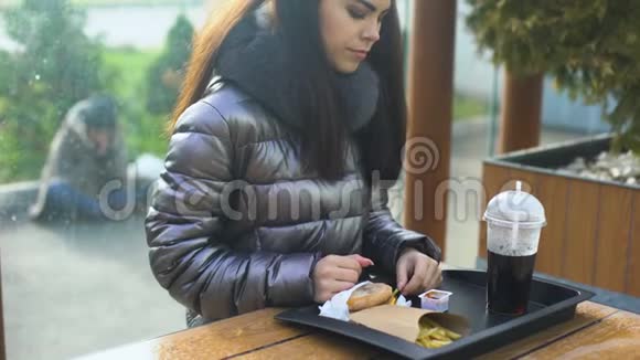 善良的女性在餐馆外看着可怜的无家可归者处理食物捐款视频的预览图
