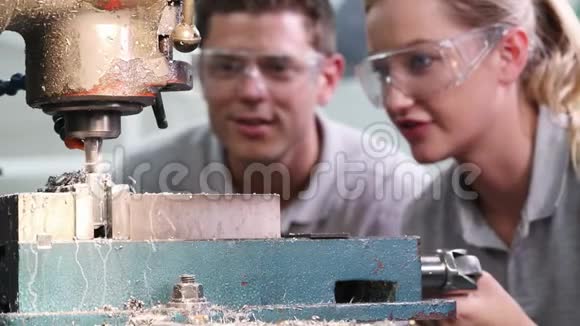 工程师培训女学徒在工厂使用钻头的拉力镜头视频的预览图