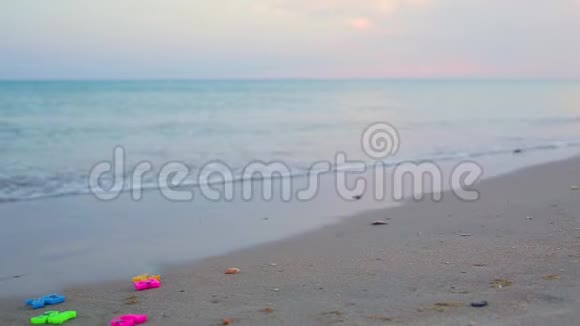 海浪冲走了躺在沙质海岸上的塑料彩色字母从收集到的字母中单词将夏季视频的预览图