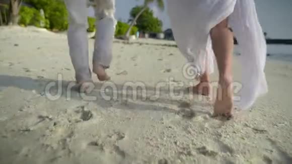 浪漫之旅年轻夫妇在豪华度假期间光着脚在潮湿的沙滩上奔跑视频的预览图