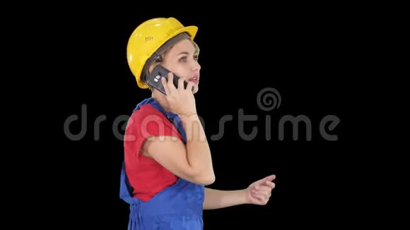 美丽的年轻建筑工女戴着黄色安全帽打电话阿尔法频道视频的预览图
