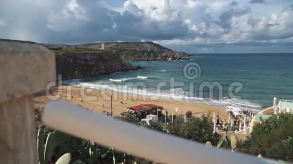 马耳他海滩景色令人惊叹美丽的沙滩小山丘和仙人掌在前景附近生长视频的预览图