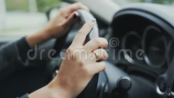 特写包裹的框架已婚女孩在汽车方向盘上的手驾驶汽车妇女的概念视频的预览图