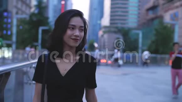 年轻的中国女人走在城市的街道上视频的预览图
