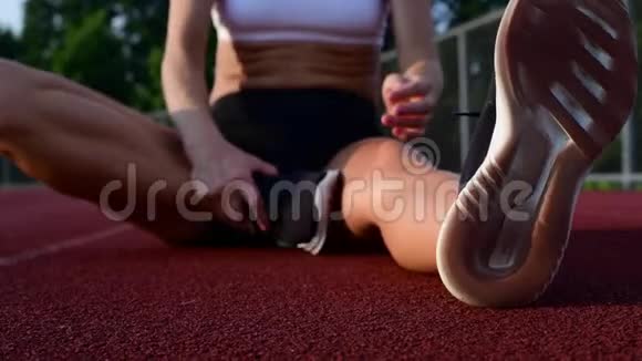 运动妇女在跑步前伸展双腿视频的预览图