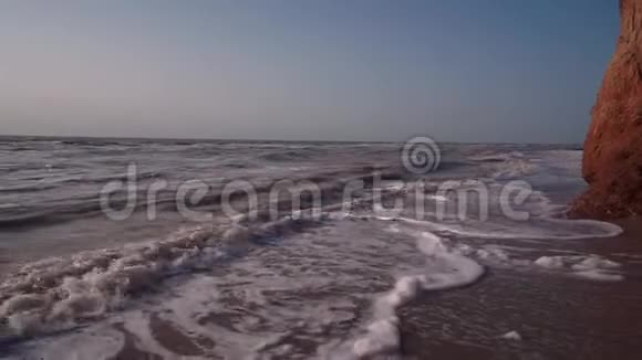 棕色肮脏的大海孤独的海滩海浪粘土岩天空视频的预览图