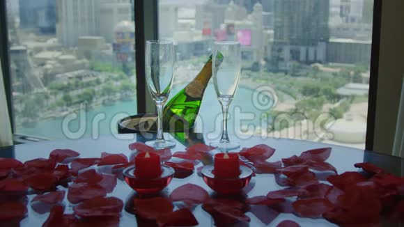 香槟和酒杯放在一张桌子上上面有红色的花瓣在大视野中视频的预览图