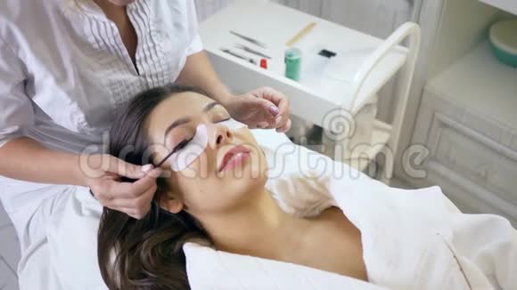 睫毛的延长程序在美容院的女客户梳头睫毛视频的预览图