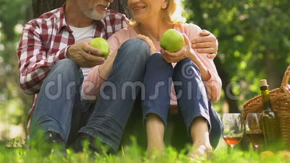 持有公园苹果天然食品和保健建议的老年夫妇视频的预览图